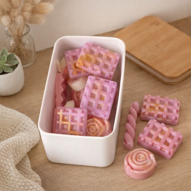 Fondant Parfumé Box Surprise, les fondants parfumés sont disposés dans la box et celle-ci est ouverte, le couvercle est posé à cotesur la table.