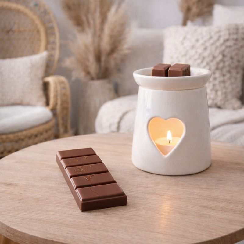 Fondant Parfumé Cola Snapbar, la tablette esst posée sur une table en bois avec un brule parfum allumée, ambiance scandinave.