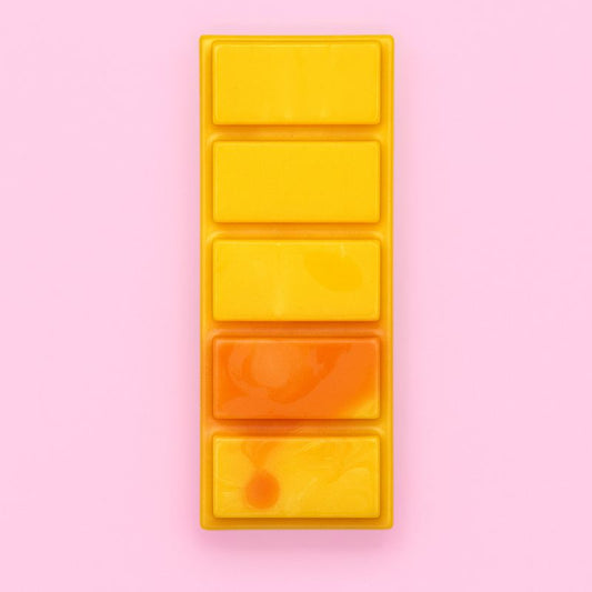 Fondant Parfumé Feu de Bois Snapbar, une barre de fondant de couleur orange, le parfum est feu de bois et sur fond rose.