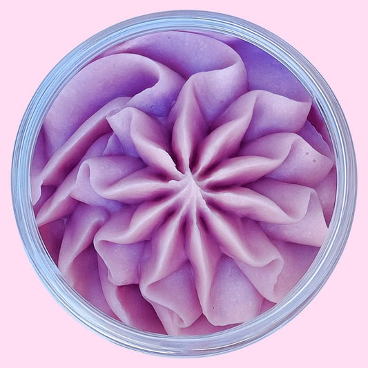 Fondant Parfumé Mûre Sauvage, de couleur violet poudré et au parfum de mure, dans son contenant en vue du dessus. Sur un fond rose.