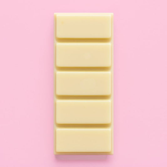 Fondant Parfumé Nougat Blanc Snapbar, de couleur jaune, en forme de tablette et parfum Nougat. Sur fond rose pâle.