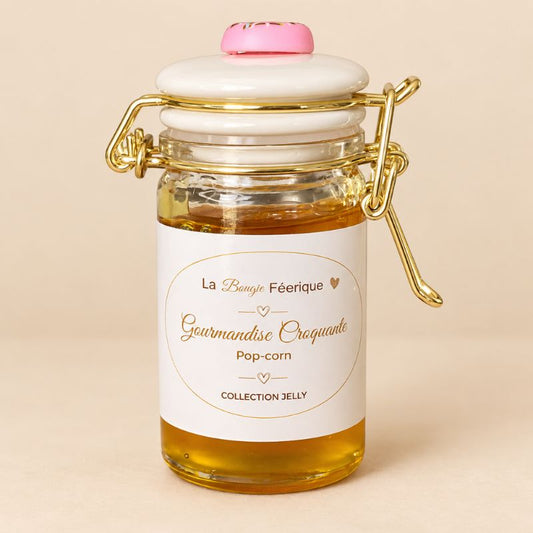 Fondant Parfumé Pop-Corn, en pot en verre, gel de couleur orange et sur fond beige clair.