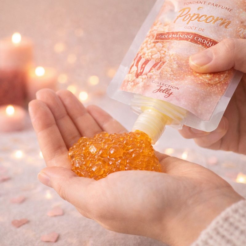 Fondant Parfumé Pop-Corn versé dans la main depuis une gourde, texture gel brillante, ambiance chaleureuse et romantique.