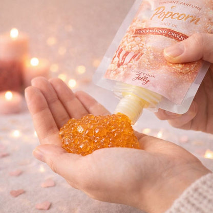 Fondant Parfumé Pop-Corn versé dans la main depuis une gourde, texture gel brillante, ambiance chaleureuse et romantique.
