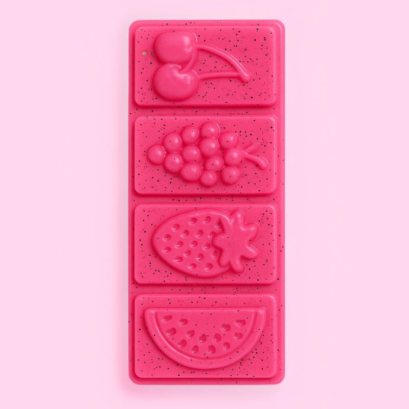 Fondant Parfumé Snapbar Fruit du Dragon, de couleur rose, en forme de tablette avec des fruits, parfum fruit du dragon et sur fond rose pâle.