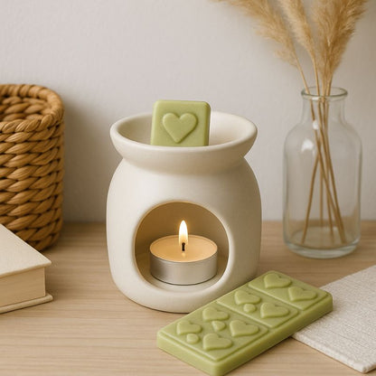 Fondant Parfumé Snapbar Mojito, un carré de la tablette est dans le brûleur qui est allumé. Le reste de la tablette est posé sur la table en bois, ambiance scandinave.