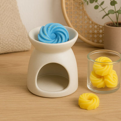 Fondant Parfumé Spirale Adoucissant, disposé dans un brûleur et posé sur une table avec d'autres fondants parfumés à côté.