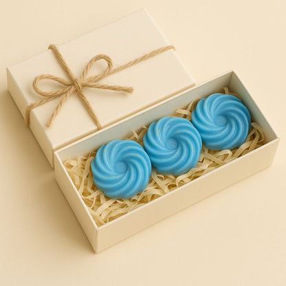 Fondant Parfumé Spirale Adoucissant, disposés dans un coffret-cadeau de couleur beige avec un nœud.