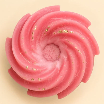 Fondant Parfumé Spirale Barbe à Papa, de couleur rose, de forme spirale et sur fond beige clair.