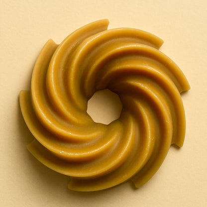 Fondant Parfumé Spirale Chocolat Cacahuète, de couleur marron, de forme spirale et sur fond beige clair.