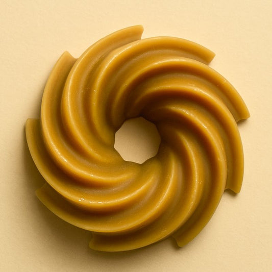 Fondant Parfumé Spirale Chocolat Cacahuète, de couleur marron, de forme spirale et sur fond beige clair.