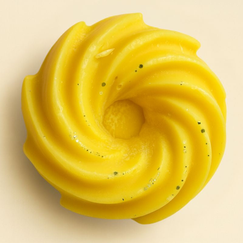 Fondant Parfumé Spirale Citron Meringué, de couleur jaune avec des paillettes, de forme spirale et sur fond beige clair.