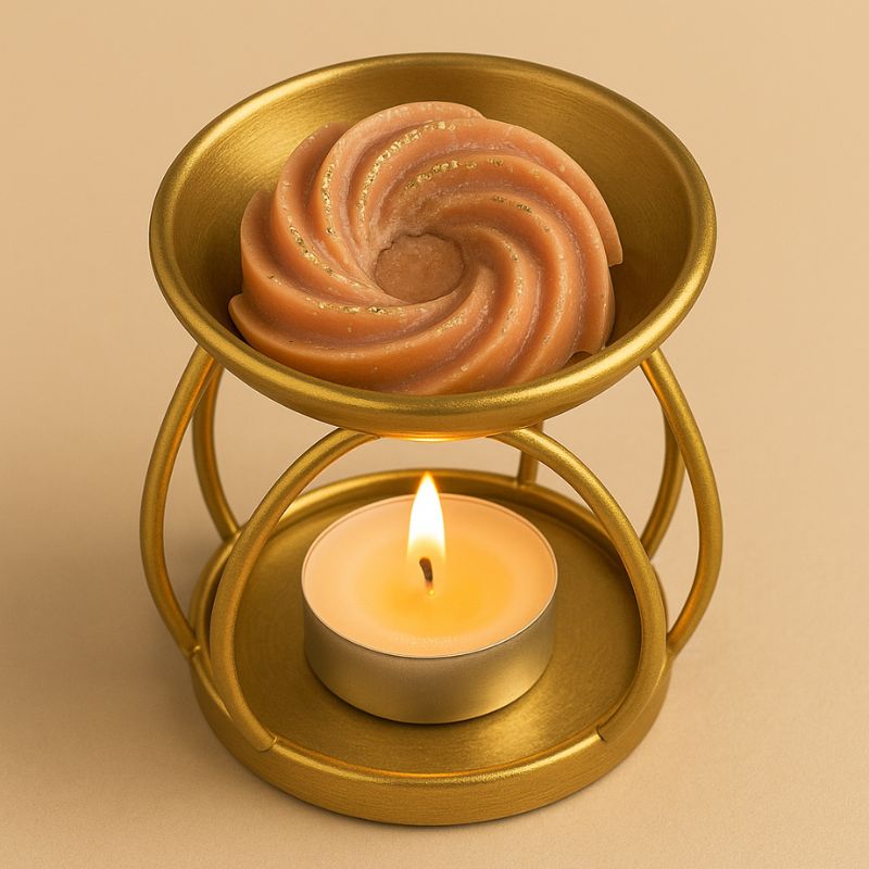 Fondant Parfumé Spirale Cookie Chocolat, disposé dans un brûle parfum doré et allumé. Sur fond beige.