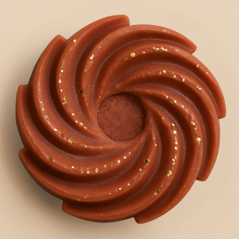 Fondant Parfumé Spirale Douceur du Canada, de couleur marron pailleté, de forme spirale et sur fond beige clair.