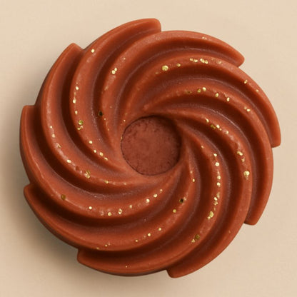 Fondant Parfumé Spirale Douceur du Canada, de couleur marron pailleté, de forme spirale et sur fond beige clair.