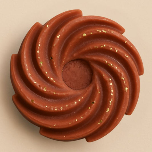 Fondant Parfumé Spirale Douceur du Canada, de couleur marron pailleté, de forme spirale et sur fond beige clair.