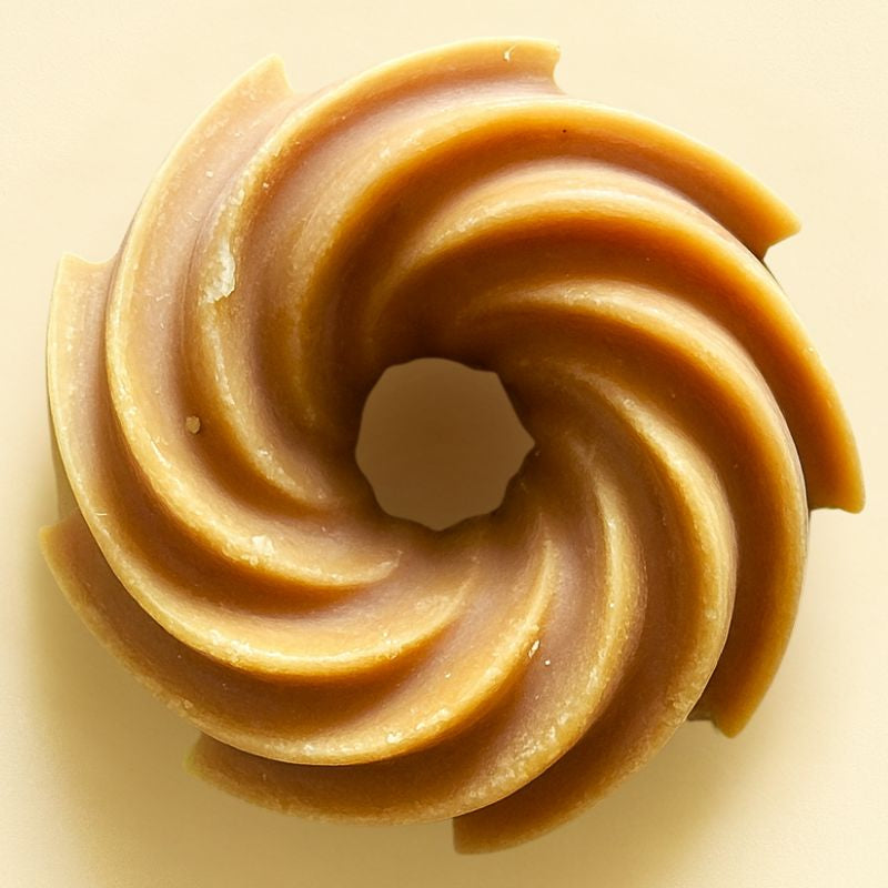 Fondant Parfumé Spirale Épicé, de couleur marron clair, avec une forme en spirale et sur fond beige clair.
