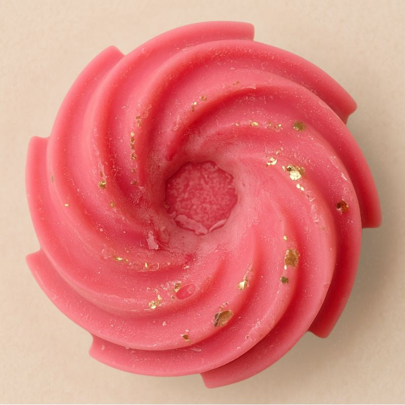 Fondant Parfumé Spirale Fruits Rouges, de couleur rose à paillette, de forme spirale et sur fond beige clair.