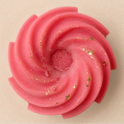 Fondant Parfumé Spirale Fruits Rouges, de couleur rose à paillette, de forme spirale et sur fond beige clair.