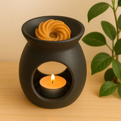 Fondant Parfumé Spirale Madeleine, disposé dans un brûle parfum noir et dans une ambiance zen.