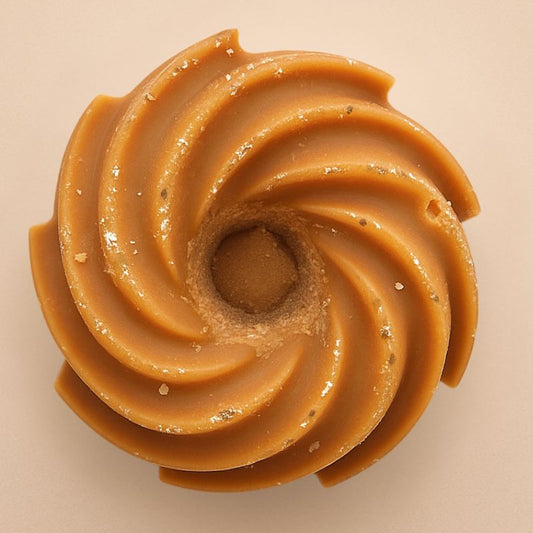 Fondant Parfumé Spirale Madeleine, de couleur marron avec des paillettes et de forme spirale. Sur fond beige clair.
