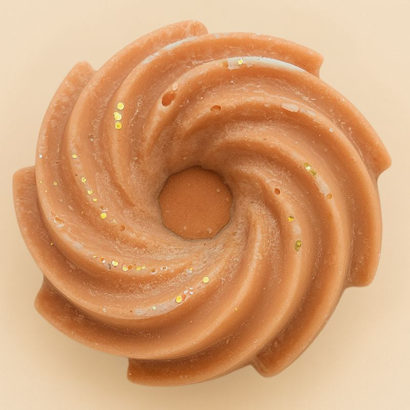 Fondant Parfumé Spirale Marron Glacé, de couleur marron avec des paillettes et sa forme est spirale. Sur fond beige.