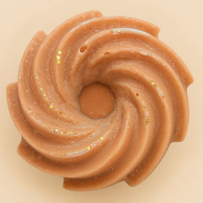Fondant Parfumé Spirale Marron Glacé, de couleur marron avec des paillettes et sa forme est spirale. Sur fond beige.
