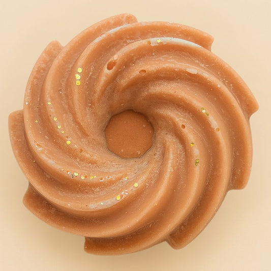 Fondant Parfumé Spirale Marron Glacé, de couleur marron avec des paillettes et sa forme est spirale. Sur fond beige.