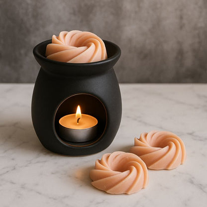 Fondant Parfumé Spirale Pop Corn, un brûleur noir est posé sur une table en marbre et avec un fondant à l’intérieur.