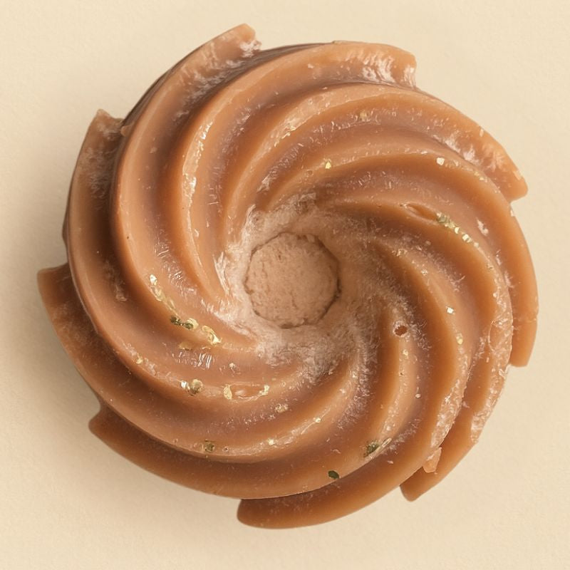 Fondant Parfumé Spirale Poudre de Cacao, de couleur marron avec des paillettes et sur fond beige clair.
