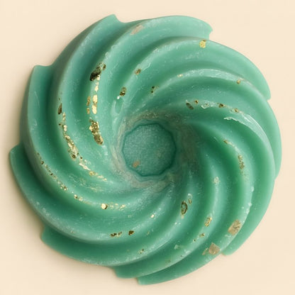 Fondant Parfumé Spirale Sapin de Noël, de couleur verte avec des paillettes, sur fond beige clair.
