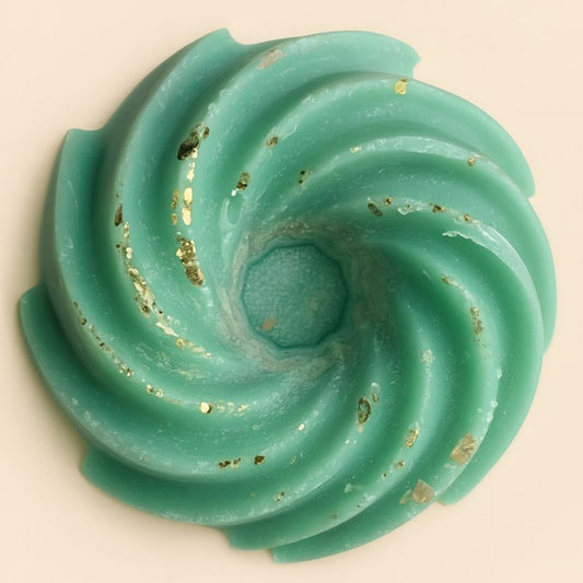 Fondant Parfumé Spirale Sapin de Noël, de couleur verte avec des paillettes, sur fond beige clair.