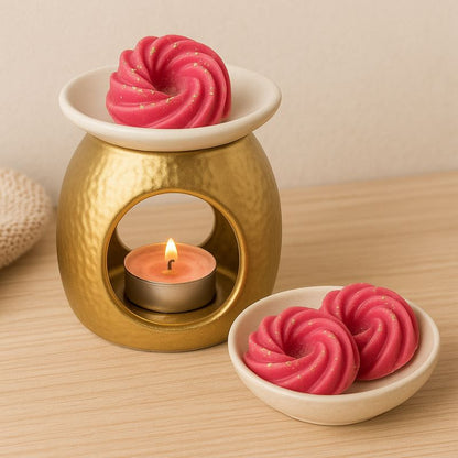 Fondant Parfumé Spirale Sucre d'Orge, disposé dans un brûleur et allumé. Il y a des fondants dans une coupelle à côté du brûleur et posé sur une table en bois.