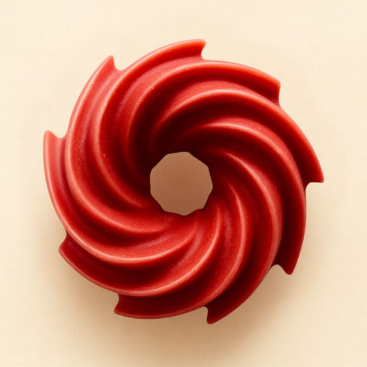 Fondant Parfumé Spirale Thé Chaï Latte, de couleur rouge, de forme spirale et sur fond beige clair.
