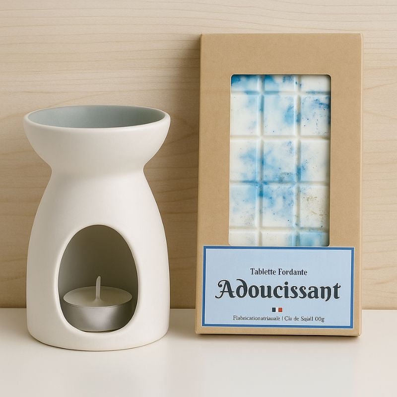 Fondant Parfumé Tablette Adoucissant, la tablette est posée à côté d'un brûleur blanc, le tout posé sur une table blanche. Ambiance scandinave.