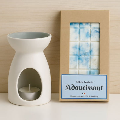Fondant Parfumé Tablette Adoucissant, la tablette est posée à côté d'un brûleur blanc, le tout posé sur une table blanche. Ambiance scandinave.