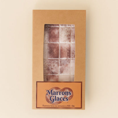 Fondant Parfumé Tablette Marron Glacé, de couleur beige avec des paillettes, dans sa boîte de présentation et sur fond beige clair.