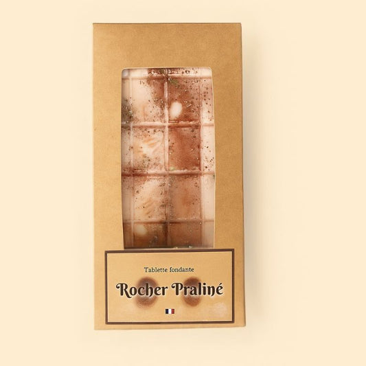 Fondant Parfumé Tablette Rocher Praliné, de couleur marron clair, dans son emballage et sur fond beige clair.