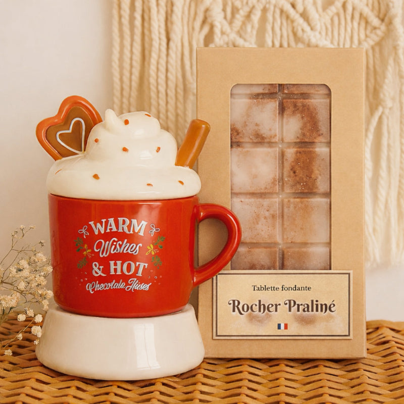 Fondant Parfumé Tablette Rocher Praliné, la tablette est dans son emballage et à côté du bruleur de Noël, dans une ambiance bohème.