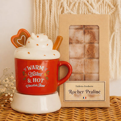Fondant Parfumé Tablette Rocher Praliné, la tablette est dans son emballage et à côté du bruleur de Noël, dans une ambiance bohème.