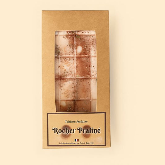 Fondant Parfumé Tablette Rocher Praliné, de couleur marron clair, dans son emballage et sur fond beige clair.