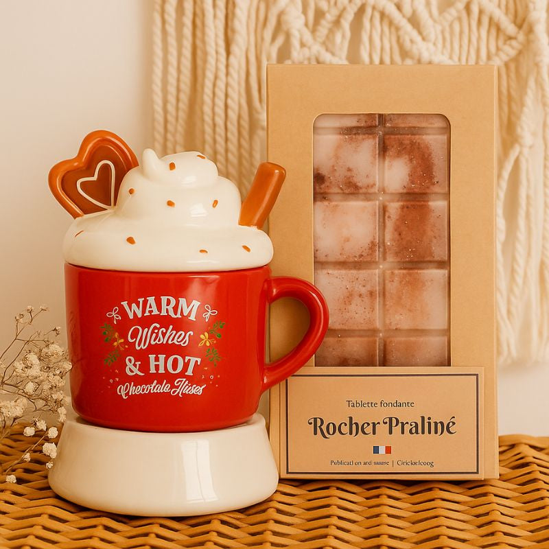 Fondant Parfumé Tablette Rocher Praliné, la tablette est dans son emballage et à côté du bruleur de Noël, dans une ambiance bohème.