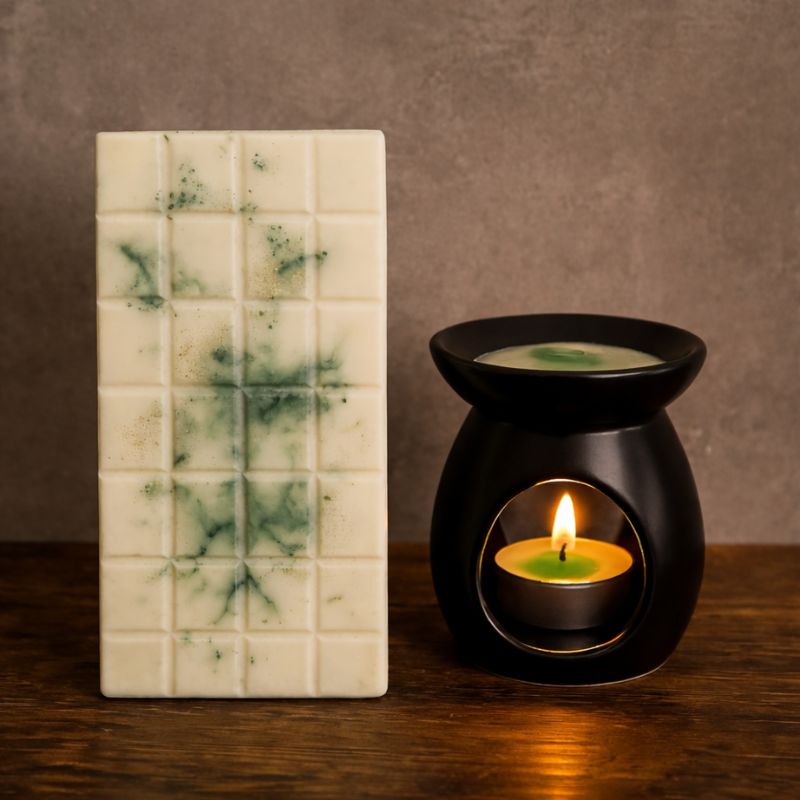 Fondant Parfumé Tablette Sapin de Noël, la tablette est posée à côté d'un brûleur qui est allumé et il y a du fondant à l’intérieur du brûleur. Ambiance vintage.