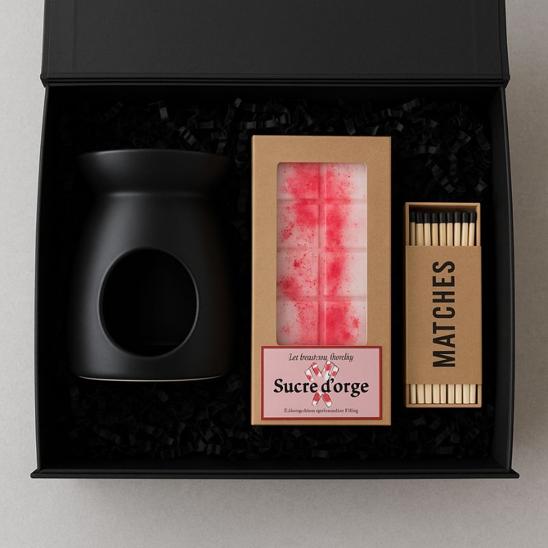 Fondant Parfumé Tablette Sucre d'Orge, en simulation dans un coffret-cadeau noir, avec un brûleur et des allumettes. Sur fond gris.