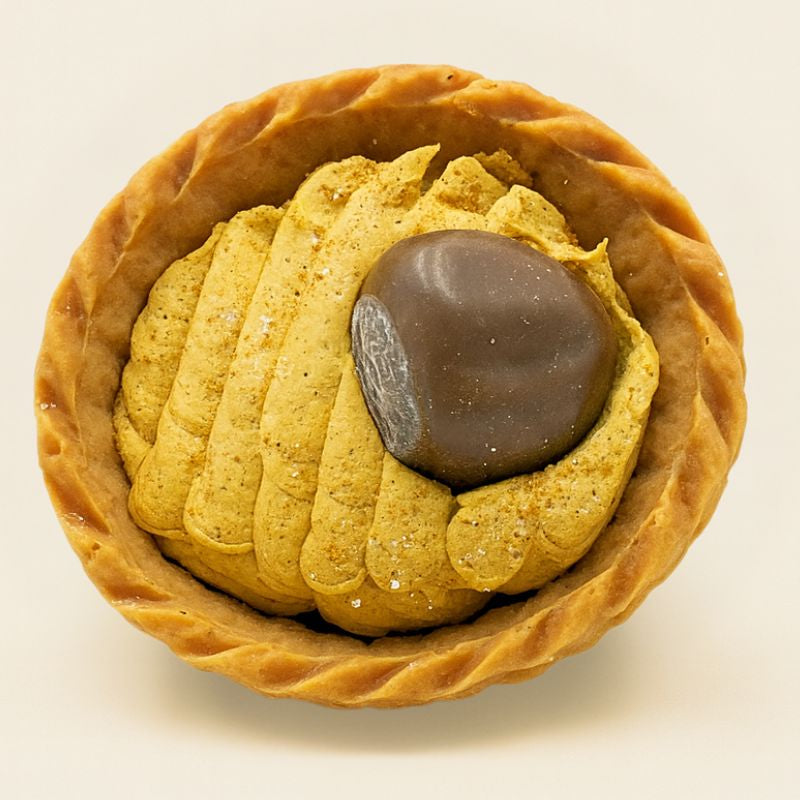Fondant Parfumé Tartelette Châtaigne Grillé, de couleur marron trompe-l'œil en forme de tartelette, sur fond beige clair.