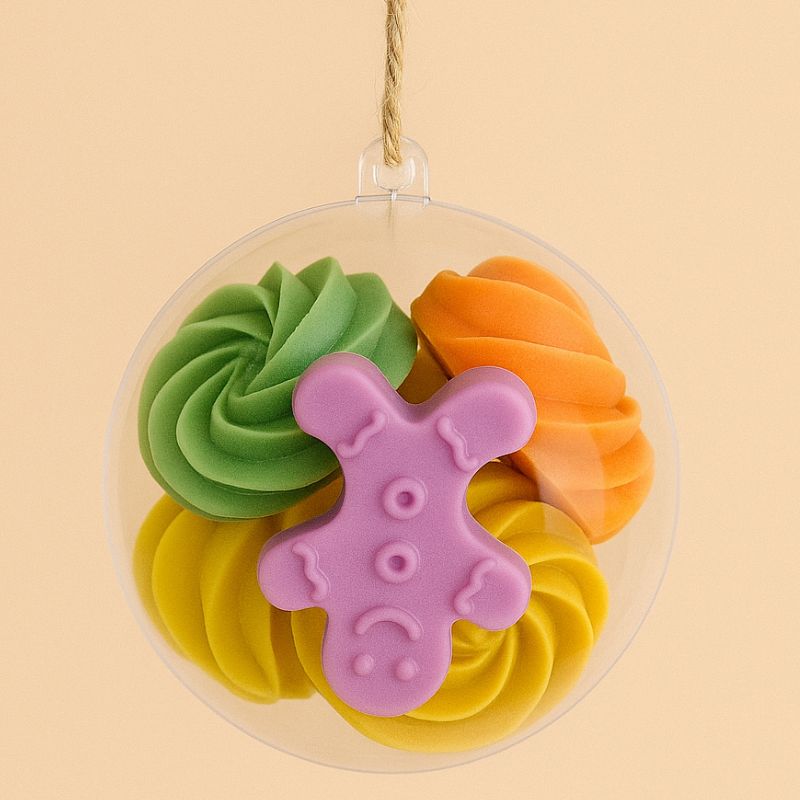 Idée Cadeau Boule Parfumée de Noël, plusieurs fondants parfumés sont enfermés dans la boule de Noël et sur fond beige clair.