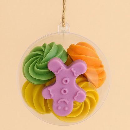 Idée Cadeau Boule Parfumée de Noël, plusieurs fondants parfumés sont enfermés dans la boule de Noël et sur fond beige clair.