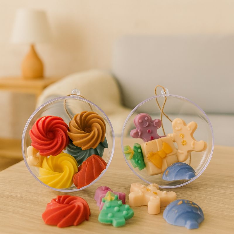 Idée Cadeau Boule Parfumée de Noël, les fondants parfumés sont disposés dans la boule transparente qui est ouverte et posée sur une table en bois.