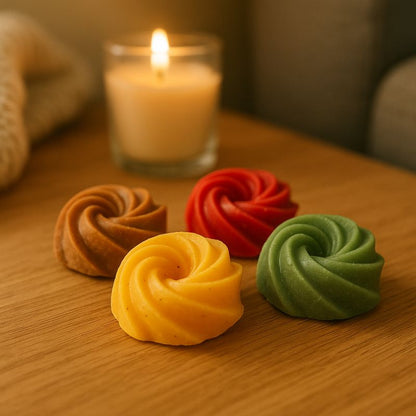 Idée Cadeau Boule Parfumée à Suspendre, des fondants parfumés sont disposés sur une table en bois et une bougie est posée à côté.