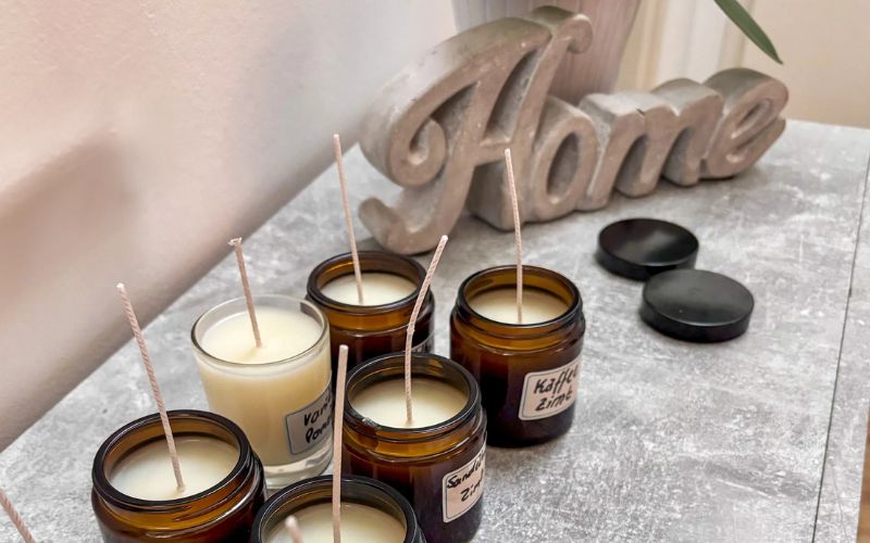 Materiel Fabrication Bougie, les bougies sont en train de refroidir après leur fabrication, posées sur une table et dans une ambiance boudoir.